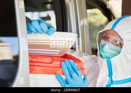 Untersuchung der Organspende durch medizinisches Fachpersonal in Schutzkleidung während des Transports und der Lieferung in der Coronavirus-Pandemie Stockfoto