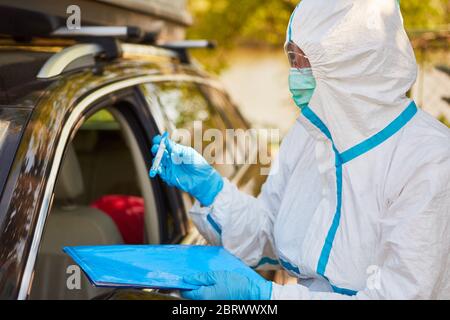 Corona-Virentest mit Rachenabstrich in Drive-in-Teststation durch Containment Scout von der Gesundheitsabteilung Stockfoto