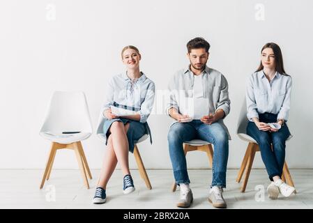 Attraktive Frau lächelt in der Nähe der Mitarbeiter im Büro an der Kamera Stockfoto