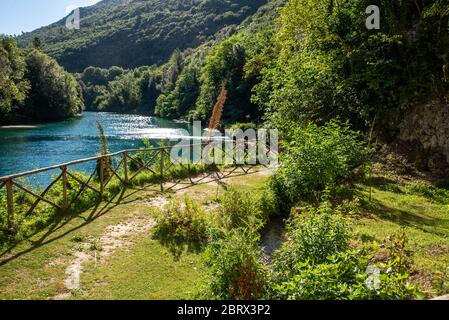 Kleiner Garten am Fluss mit blauem Wasser Stockfoto