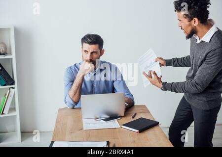 Wütend afroamerikanischen Geschäftsmann Streit an Kollegen in der Nähe Laptop im Büro Stockfoto