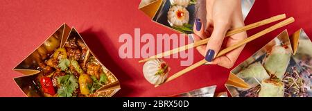 Panorama-Konzept der Frau hält Essstäbchen mit gedämpftem Brötchen in der Nähe von leckeren chinesischen Speisen in Take-away-Boxen auf rot Stockfoto
