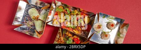 Panorama-Ernte von köstlichen chinesischen Speisen in Take Away Boxen auf rot Stockfoto