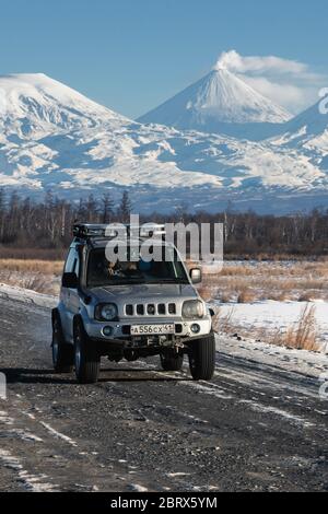 Japanische SUV Suzuki Jimny Fahren entlang der Straße auf Hintergrund schöne Winterlandschaft Reiseziele aktiven Vulkan Kluchevskaya Sopka Stockfoto