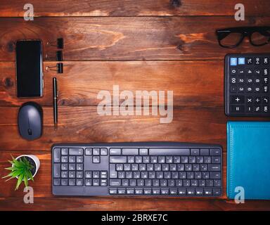 Ordentlich gefaltete Büromaterialien auf dem Schreibtisch zu Hause. Vintage Holztisch. Das Konzept des Home-Working und des Freiberufens Stockfoto