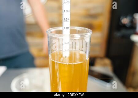 Messung des Alkoholgehalts in Bier. Hydrometer in einem Glas Bier. Stockfoto