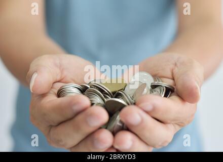 Münzen in zwei Händen. Konzept Geldeinsparung. Stockfoto