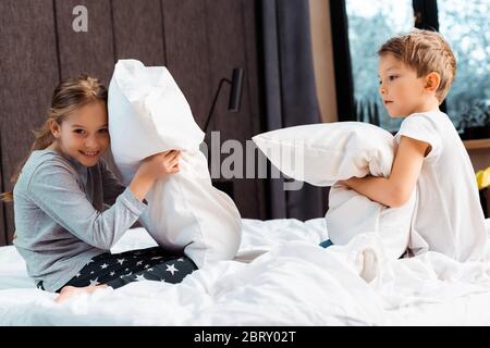 Nette Geschwister Kopfkissen kämpfen im Schlafzimmer Stockfoto