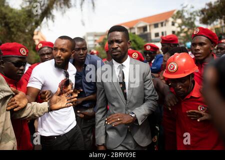 Der ÔPeople PowerÕ-Führer Bobi Wine verlässt am 24 2020. Februar das von Anhängern umgebene Gericht in Kampala, Uganda. Er bat den Richter, von der ugandischen Regierung Ôconsider verfassungswidrig attemptsÕ zu sein, seine politischen Versammlungen zu stoppen, die Wine nach seiner Verhaftung und Vergasung Anfang des Jahres aufgeben musste. Bobi Wine, dessen richtiger Name Robert Kyagulanyi Sentamu ist, ist ein Popstar und Oppositionsführer im Rahmen der Kampagne "People Power". Im Juli 2019 wurde ihm angekündigt, dass er bei den Wahlen 2021 Ugandas langjährigen Präsidenten Yoweri Museveni übernehmen wird. Stockfoto