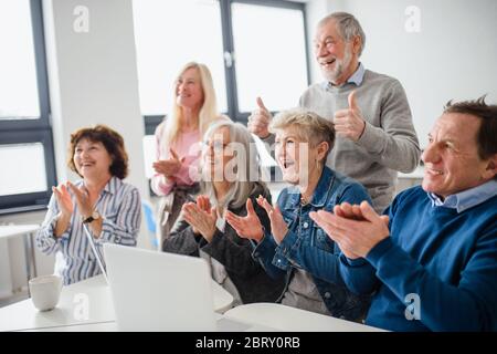 Gruppe von fröhlichen Senioren, die Computer- und Technologieunterricht besuchen. Stockfoto