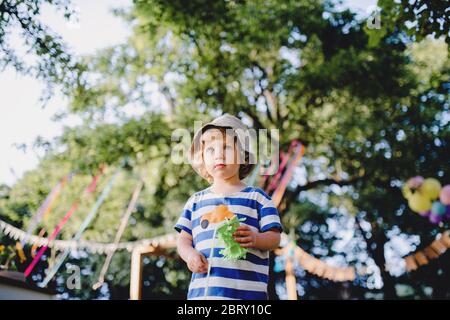 Low-Winkel-Ansicht von kleinen Jungen im Freien auf Gartenparty stehen, spielen. Stockfoto