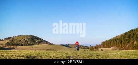 Aktive ältere Frau mit E-Bike Radfahren im Freien in der Natur. Stockfoto