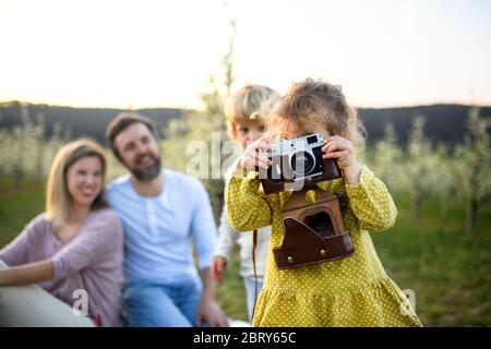Familie mit kleinen Kindern im Freien im Frühling Natur sitzen, Fotos machen. Stockfoto