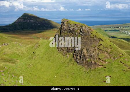 Cnoc A' Mheirlich (266M) & Dum Mor (278M im Schatten) mit Bergen von Wester Ross hinter Staffin Bay vom Quiraing Path, Trotternish Ridge, Isle o Stockfoto