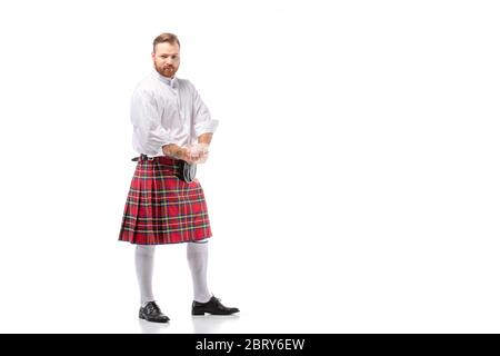 Schottischer Rotschopf-Mann in rotem Kilt auf weißem Hintergrund Stockfoto