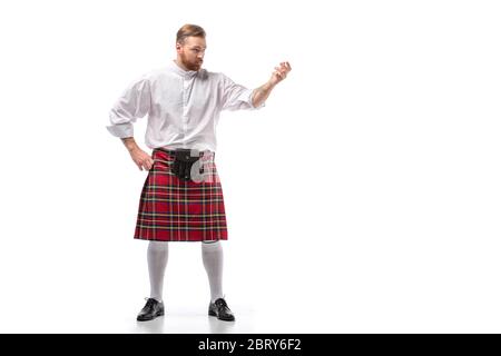 Ernster schottischer Rotschopf-Mann in rotem Kilt auf weißem Hintergrund Stockfoto
