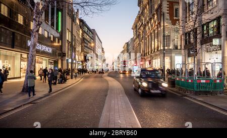 Oxford Street, London. Shopper und Verkehr in der Nacht im Einkaufs- und Einkaufsviertel der britischen Hauptstadt. Stockfoto