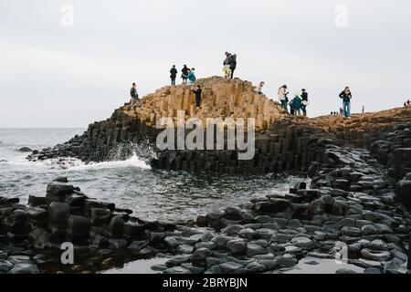 Touristen genießen die Giants Causeway UNESCO-Weltkulturerbe in Nordirland, die jetzt von der National Trust verwaltet wird. Stockfoto