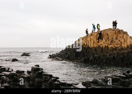 Touristen genießen die Giants Causeway UNESCO-Weltkulturerbe in Nordirland, die jetzt von der National Trust verwaltet wird. Stockfoto