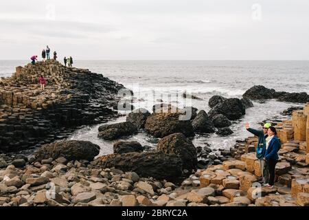 Touristen genießen die Giants Causeway UNESCO-Weltkulturerbe in Nordirland, die jetzt von der National Trust verwaltet wird. Stockfoto