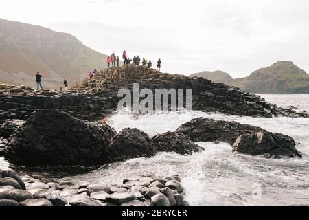 Touristen genießen die Giants Causeway UNESCO-Weltkulturerbe in Nordirland, die jetzt von der National Trust verwaltet wird. Stockfoto