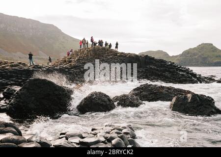 Touristen genießen die Giants Causeway UNESCO-Weltkulturerbe in Nordirland, die jetzt von der National Trust verwaltet wird. Stockfoto