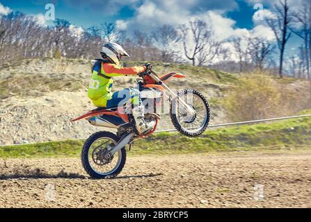 Motocross, steht ein Fahrer auf dem Hinterrad eines Fahrrads, Reiten auf dem Hinterrad. Extreme, Industrie, Motorrad-Cross-Country-Reiten für extreme. Stockfoto