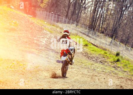 Motocross, steht ein Fahrer auf dem Hinterrad eines Fahrrads, Reiten auf dem Hinterrad. Extreme, Industrie, Motorrad-Cross-Country-Reiten für extreme. Stockfoto