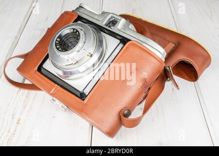 Eine ganze Vintage Kamera in braunem Gehäuse auf weißem Holz Stockfoto