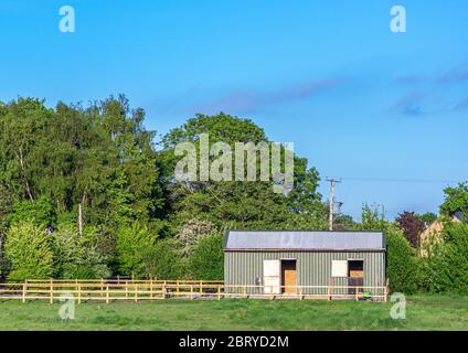 Ein kleines Pferdekoppel mit zwei Stall an einem sonnigen Tag mit blauen Skys. Stockfoto