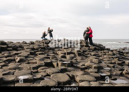 Touristen genießen die Giants Causeway UNESCO-Weltkulturerbe in Nordirland, die jetzt von der National Trust verwaltet wird. Stockfoto