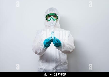 Arzt trägt PSA - Kostüm, Handschuhe und chirurgische Gesichtsmaske in Superhelden Umhang mit Flasche antiseptischen Gel. Konzept der Superhelden medizinischen Personal Stockfoto