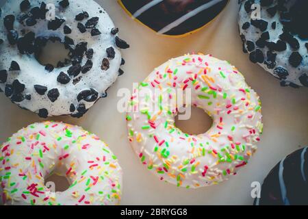 Flach legen Bild von Donut mit weißer Glasur und bunten Hunderte und Tausende Pyramiden anderen verschiedenen Donuts Stockfoto