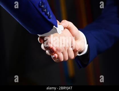 Händeschütteln bei Geschäftstreffen. Erfolgreiche Geschäftsleute Händeschütteln nach guter Deal. Partnerschaft, Vertrag und finanzielle Unterstützung. Halten der männlichen Hände. Geschäftspartner nach Vertragsunterzeichnung. Stockfoto