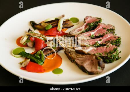 Racks mit Lamm auf Platte, über schwarzen Hintergrund isoliert Stockfoto