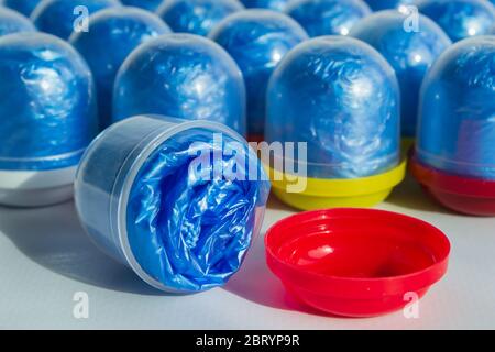 Blaue Schuhüberzüge in einzelnen Kapseln mit mehrfarbigen Kappen. Einmal-Überziehschuhe. Schutzkonzept. Selektiver Fokus, Nahaufnahme. Helles Licht Stockfoto