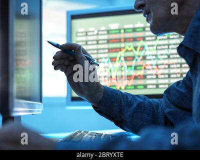 Nahaufnahme der Aktienmarkttrader, die die Kursdaten auf dem Bildschirm analysieren. Stockfoto