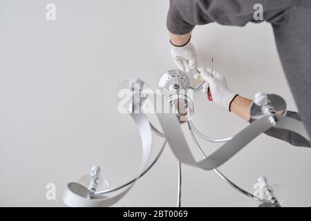 Installation Deckenleuchte, Hände von Elektriker Befestigung Kronleuchter Stockfoto