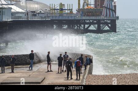 Brighton UK 22. Mai 2020 - Wellenbeobachter am Brighton Palace Pier heute an einem sonnigen, aber windigen Tag. Der Strand und die Strandpromenade waren heute viel ruhiger, nachdem das heiße Wetter während der Sperrung des Coronavirus COVID-19 in Großbritannien beendet wurde. Quelle: Simon Dack / Alamy Live News Stockfoto