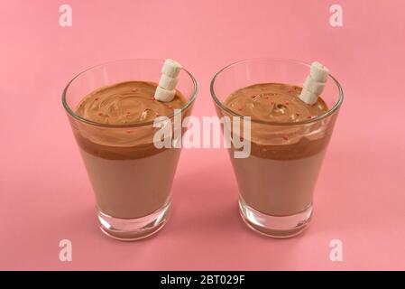 Zwei Gläser trendy koreanischen Dalgona Kaffee mit Marshmellows auf rosa Hintergrund Stockfoto