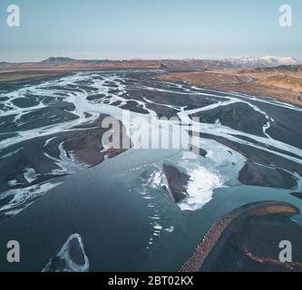 Luftdrohnenaufnahme eines Gletscherflusssystems im Süden Islands während der Mitternachtssonne und des Sonnenuntergangs. Gletscherbett, Delta in Island. Stockfoto