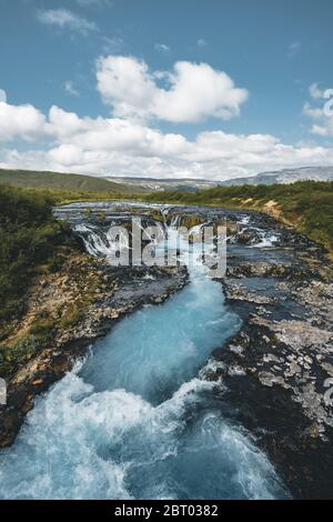 Unglaubliche Aussicht auf den Bruarfoss Wasserfall. Der 'Islands Bluest Waterfall'. Blaues Wasser fließt über Steine. Mitternachtssonne von Island. Besuchen Sie Island. Schönheit Stockfoto