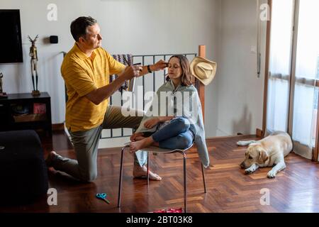 Vater schneidet seiner Tochter die Haare zu Hause, während der Zeit des Aufenthalts zu Hause Lockdown. Stockfoto