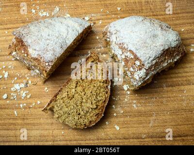 Zwei Viertel eines frisch gebackenen Soda Brotes mit einer Scheibe auf einem hölzernen Brotscheibe geschnitten Stockfoto