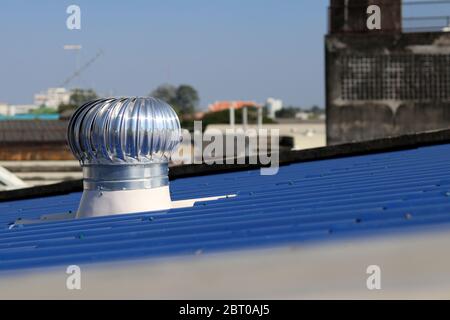 Turbinenlüfter auf dem blauen Dach installiert. Der Turbinenventilator hilft, die Luft jederzeit zu fließen. Stockfoto