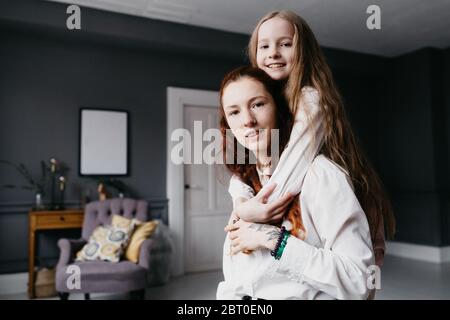 Zwei Schwestern umarmen sich im Loft, die Freundschaft, Vertrauen, Ähnlichkeit darstellen Stockfoto