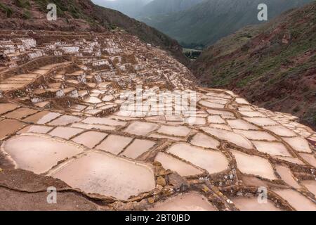 Berglandschaft mit Moray Maras terrassierten Salzbergwerk im Vordergrund bei Cusco, Peru. Stockfoto