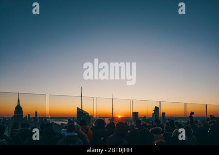 Blick auf die Skyline von Manhattan mit beleuchteten Wolkenkratzern bei Sonnenuntergang, New York City Stockfoto