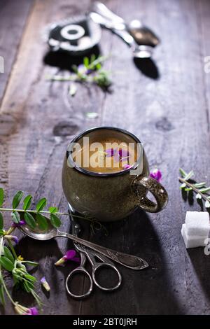 Aromatischer Kaffee auf altem Tisch.Espresso mit Blumen.leckeres Essen und Trinken.Vintage-Stil. Stockfoto