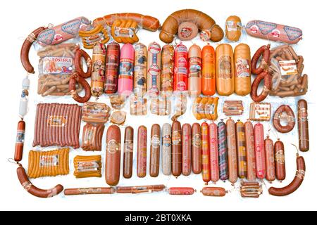 Viele Schinken Wurst Paket auf grünem Hintergrund isoliert. Eine Gruppe von ganzen schmackhaften gekochten Würstchen. Eine Menge Würstchen. Set mit verschiedenen leckeren Würstchen Stockfoto